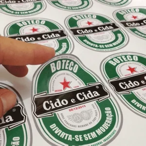 Folha de adesivos de vinil com meio corte em formatos personalizados, mostrando um adesivo sendo destacado facilmente.